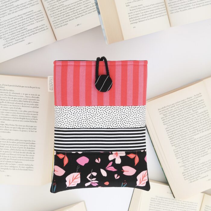 Funda de libro confeccionada con distintas telas en tonos rosa, rojo y blanco y negro. Funda acolchada y única para proteger tus libros. El regalo perfecto para los amantes de la lectura.