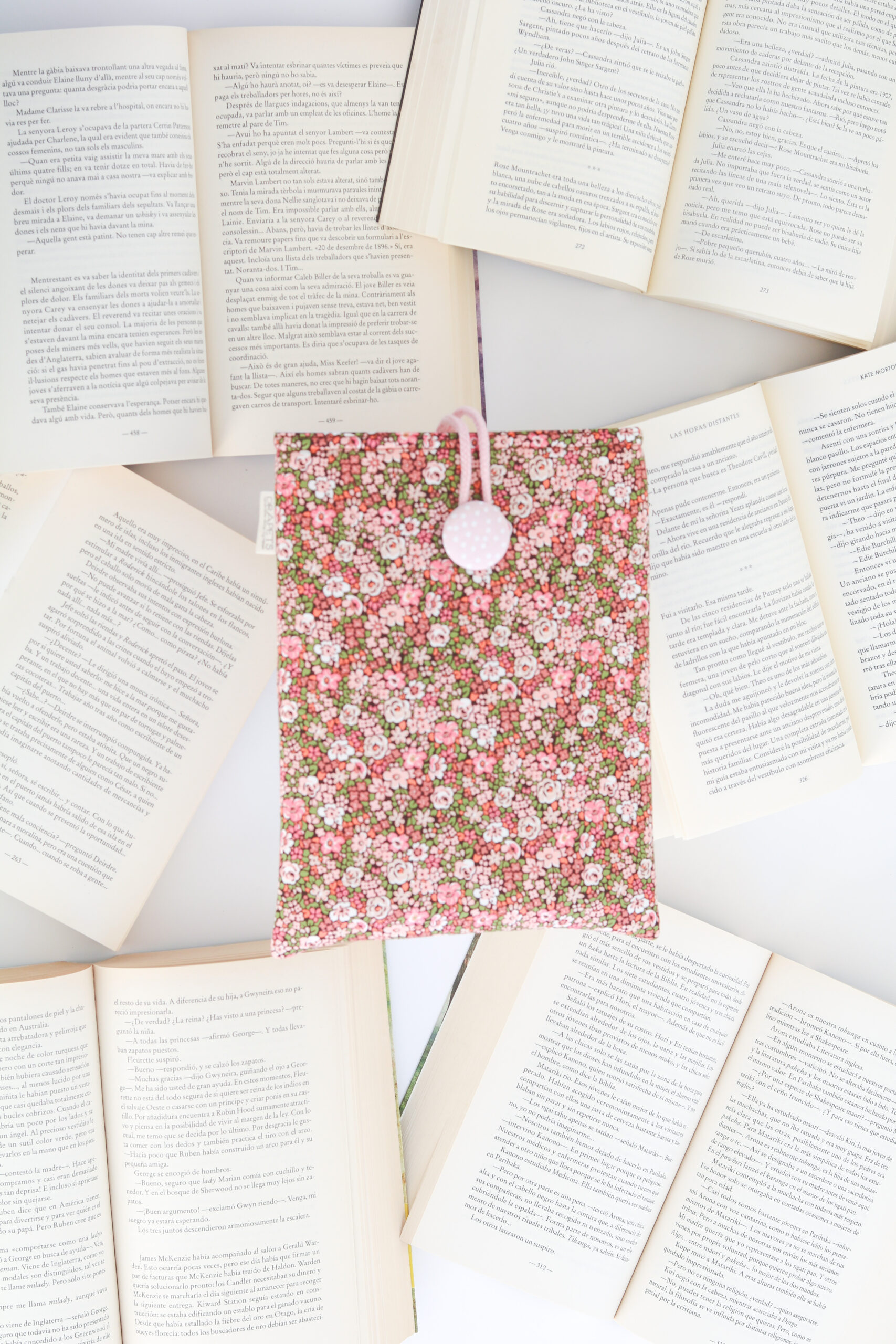 Funda de Libro Liberty Pink, estampado floral en tonos rosas y verdes con base marrón. Detalles de cordón y botón en rosa junto con el forro interior.