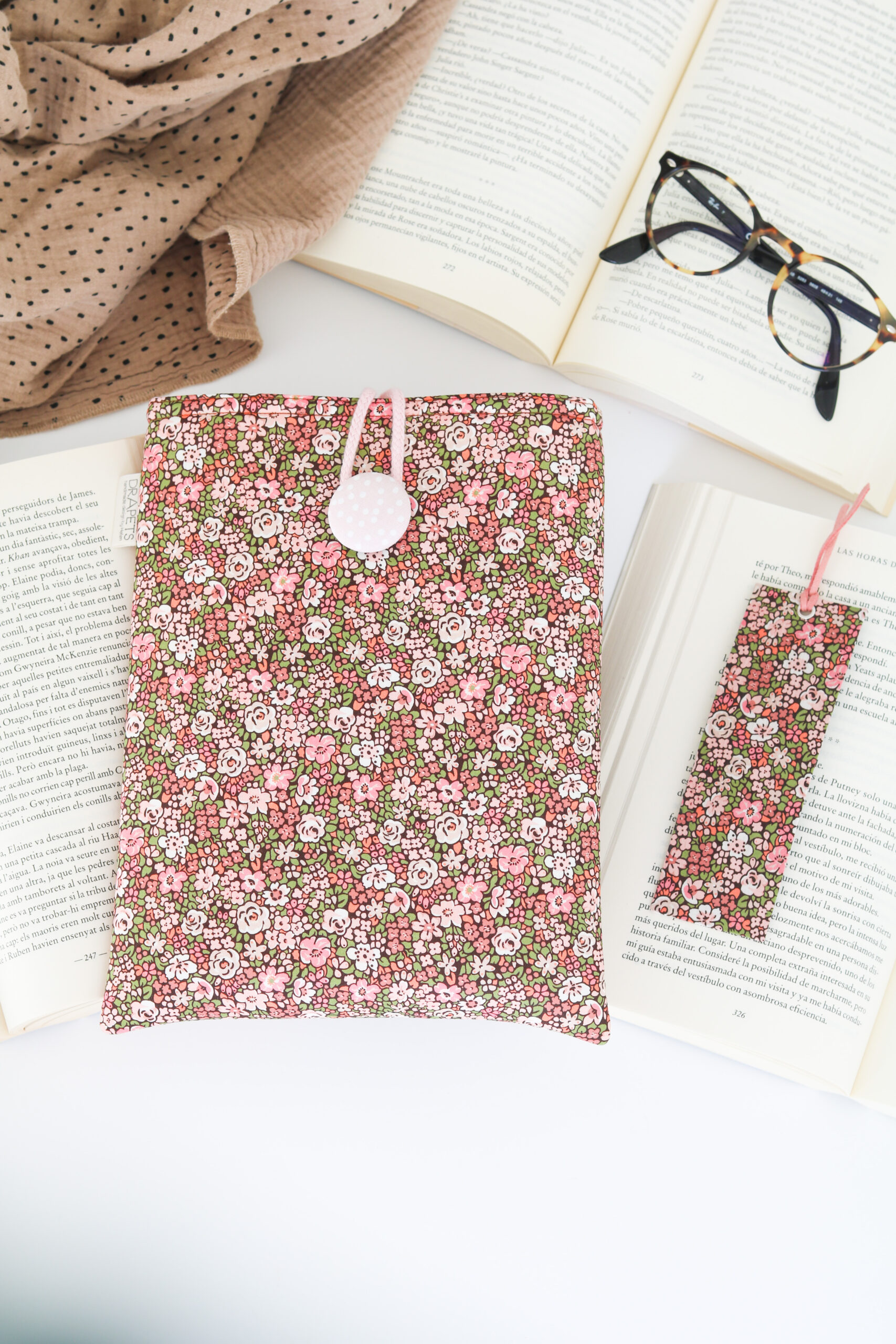 Funda de Libro Liberty Pink en flores rosas, verdes con base marrón con forro interior blanco y rosa que le da luz.