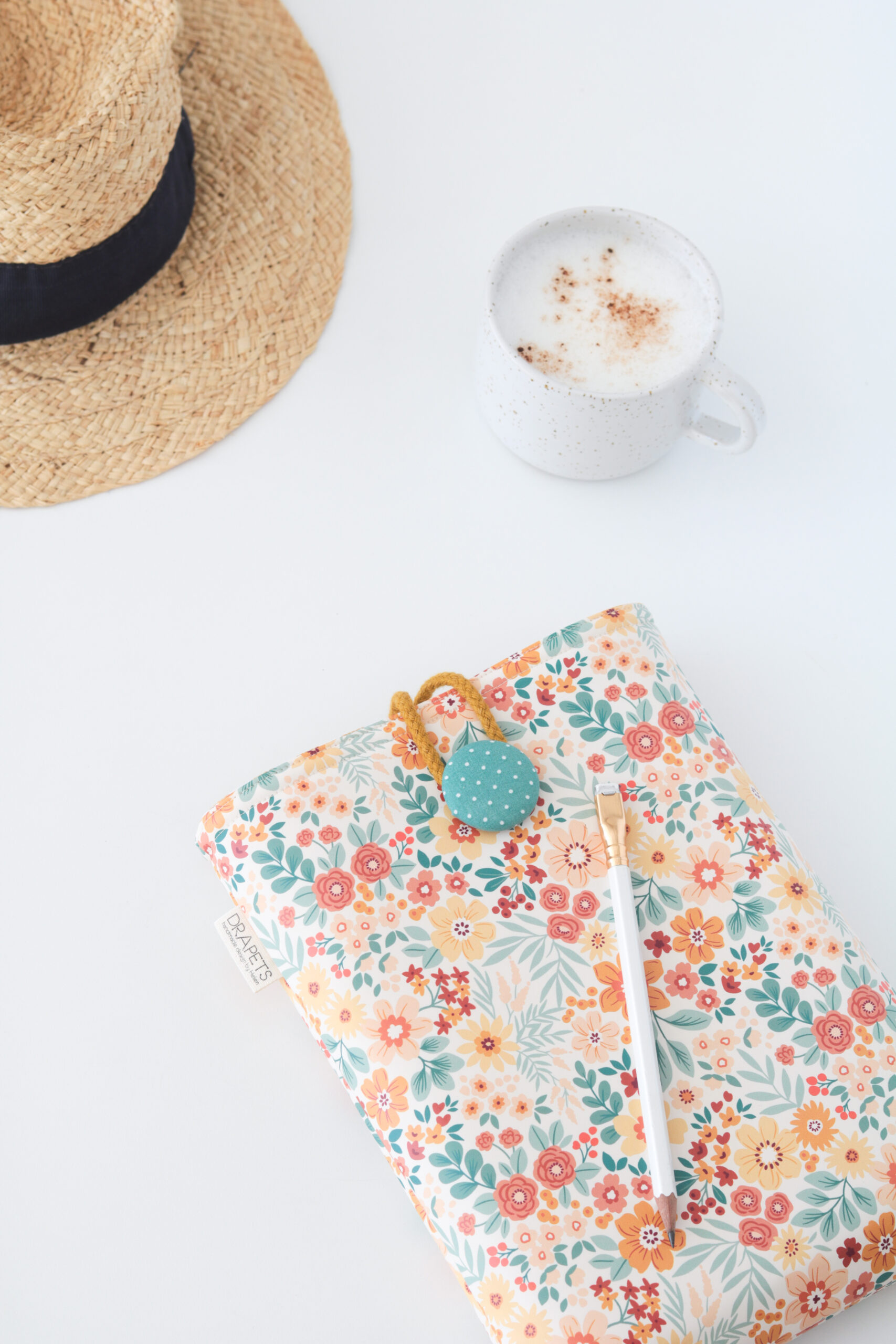 Funda de libro impermeable con estampado floral sobre fondo blanco roto, modelo Flower de Drapets.